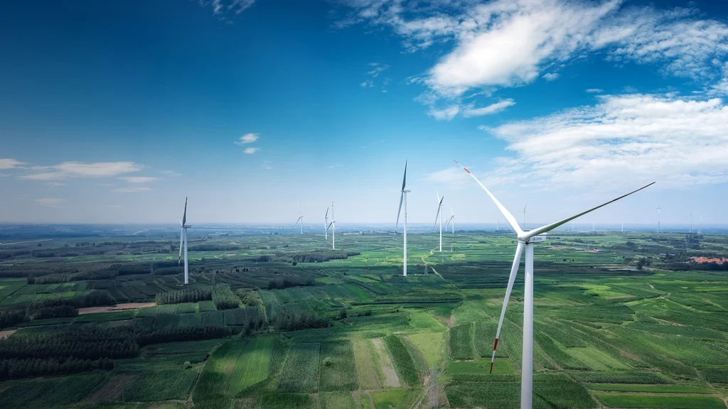 Wind turbines across green fields under a clear sky