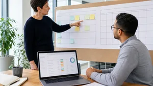 Product lead and engineer reviewing a sprint board, calendar and release checklist in an Australian office