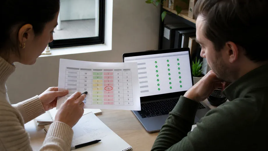 Aged care SaaS product lead and engineer comparing a printed quality-indicator table with green on-screen validation ticks